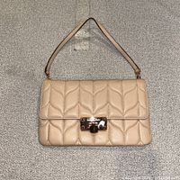 Front view of quilted blush leather Michael Kors Sloan bag with strap