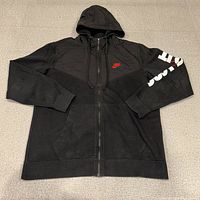 Front view of black Nike zip-up hoodie fully zipped