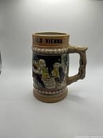 Front view of stein showing Old Vienna text, tavern scene relief, handle