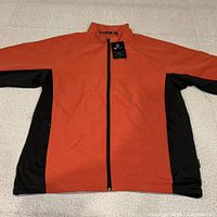 Front view of orange and black ONTOUR windbreaker laid flat