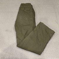 Folded olive cargo pants showing flap pocket