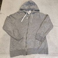 Front view of gray Reebok zip hoodie laid flat