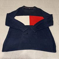 Full front view of navy sweater showing flag panel, sleeves folded