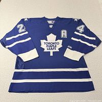 Front view of blue CCM Toronto Maple Leafs jersey showing number 24 shoulders, A patch, striping