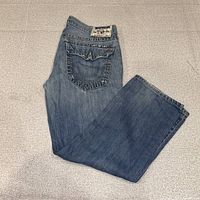 Full view of folded blue True Religion jeans