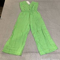 Full view of green Zara strapless pantsuit laid flat