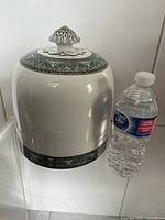 Full view of ceramic cheese dome alongside water bottle for scale