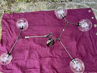 Full chandelier laid flat showing five arms and globes