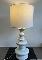 Full view of illuminated lamp with drum shade