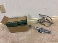 Box labeled American Standard with faucet, drain and hardware displayed