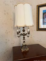 Full view of lamp on table showing shade, base and arms
