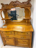Full view of dresser base with four drawers, two cabinet doors, attached mirror and shelves