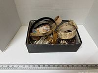 Top view of shoe box containing assorted belts