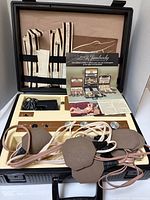 Open case showing stimulator console, electrode pads, leads, straps, AC adapter and brochure