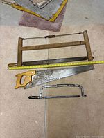 Overall view of three saws laid out with measuring tape