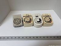 Group shot of four plug-in timers beside ruler