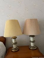 Pair of lamps on bedside table with shades visible