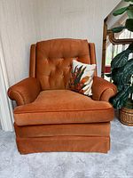 Front view of upholstered armchair showing color, style, and cushion