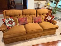 Front view of Sklar mustard velvet sofa with four decorative pillows