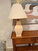 Full view of lamp on table showing ceramic base and shade