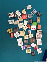 Group of approx 40 matchbooks spread out showing variety