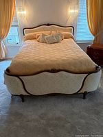 Full view of queen bed with upholstered headboard, bedding and pillows