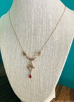 Full view of necklace on display bust showing overall length and pendant drop