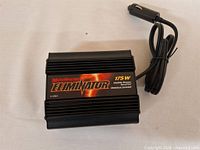Front view of MotoMaster Eliminator 175W inverter with attached 12V plug