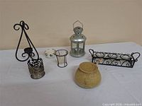 Group shot of all candle holders and wicker jar on white surface