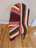 Throw draped over chair showing overall size and multicolor striping