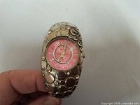 Front view showing pink dial and bubble-textured band