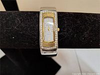 Front view showing dial, rhinestones, gold-tone bezel