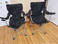 Two black folding lawn chairs front view