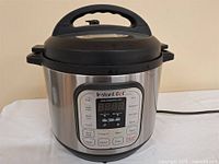 Front view of Instant Pot IP-DUO80 showing full unit with lid and power cord