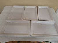 five white plastic rectangular trays on table