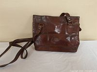Full view of brown leather Aldo handbag with strap
