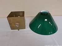 Green glass conical shade and brass square shade side by side
