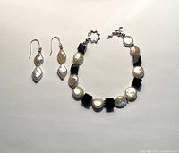 Bracelet and pair of earrings laid flat showing full design.