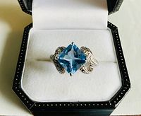 Top view of sterling ring with blue square stone in box