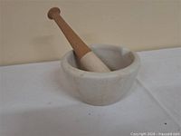 Mortar with pestle resting inside showing scale and material