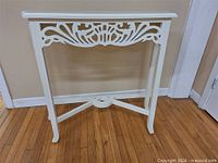 Full view of white painted console table front and legs