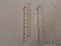 Two glass rain gauge tubes side by side
