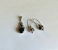 Pendant and earrings set laid out on white background