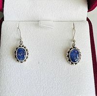 Frontal view of both earrings in presentation box showing stone color and overall design