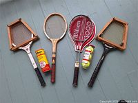 Four racquets, two ball containers, two presses laid out