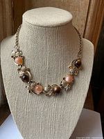 Full view of gold-tone lucite and rhinestone necklace on display bust