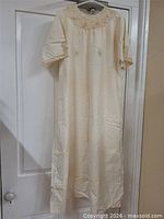 Full view of cream nightdress hanging