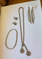 full set laid out: necklace, bracelet, two pairs earrings