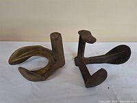 Two cast iron cobbler lasts side by side