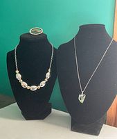 Full view of the three jewellery pieces displayed on two necklace stands